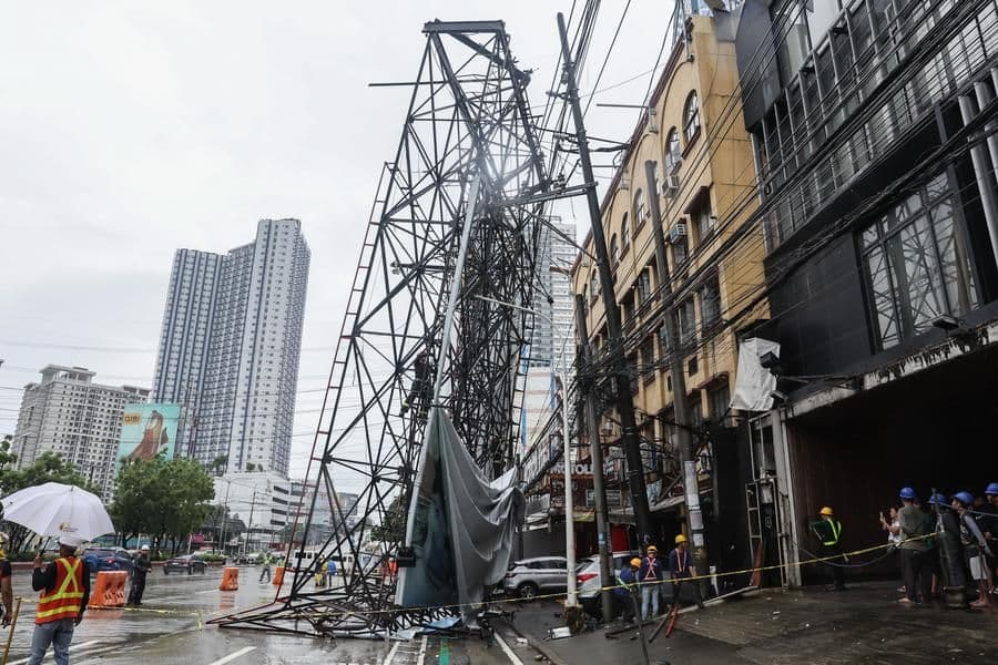 Des secouristes près d'un panneau d'affichage effondré à Quezon City, aux Philippines, après le passage du typhon Wipha.