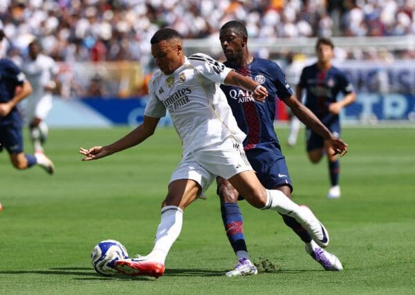 Deux joueurs de football s'affrontant pour le ballon, illustrant les duels tactiques du match.