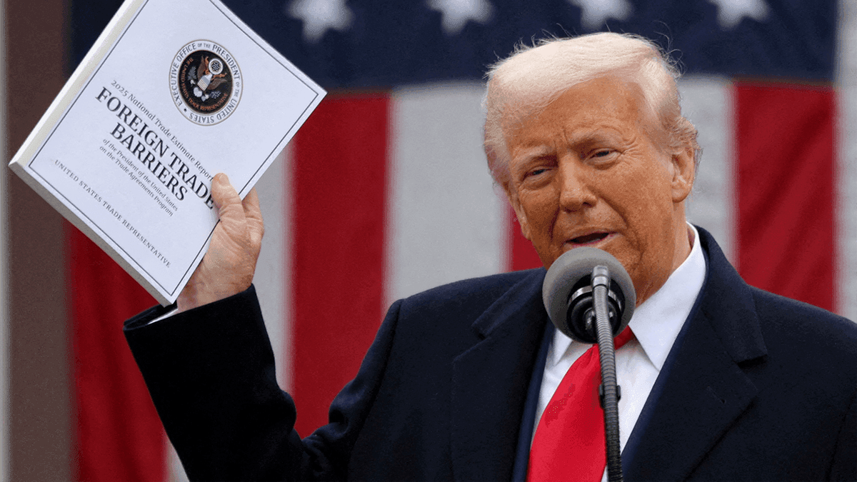 Donald Trump holding a document on foreign trade barriers, symbolizing his 'America First' economic vision and tariff policy.