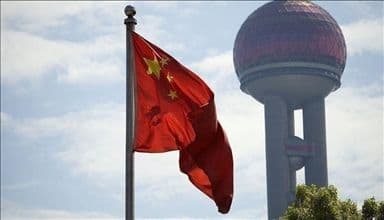 Drapeau chinois devant un paysage urbain, illustrant l'influence géopolitique et économique de la Chine.