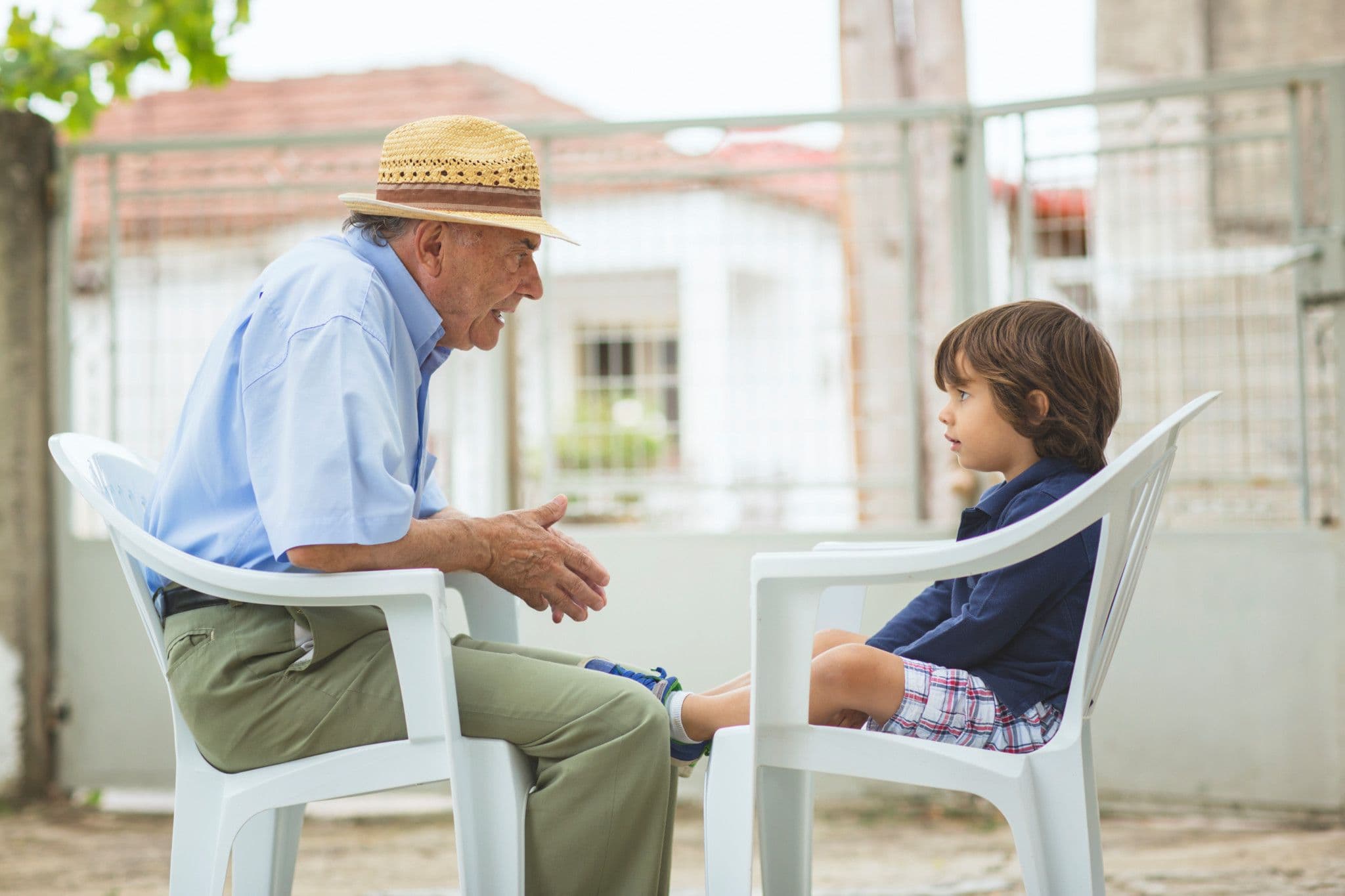 Ein älterer Mann mit Strohhut unterhält sich mit einem Jungen, symbolisierend den Zusammenhalt in der ländlichen Gemeinschaft von Oberhasli.