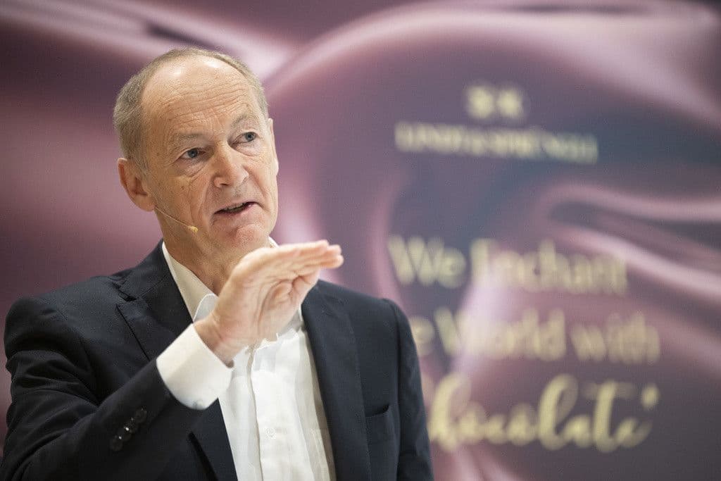 Ein Unternehmensleiter spricht auf einer Pressekonferenz, was die Notwendigkeit der Kommunikation und des Vertrauensmanagements bei ethischen Herausforderungen für Nestlé widerspiegelt.