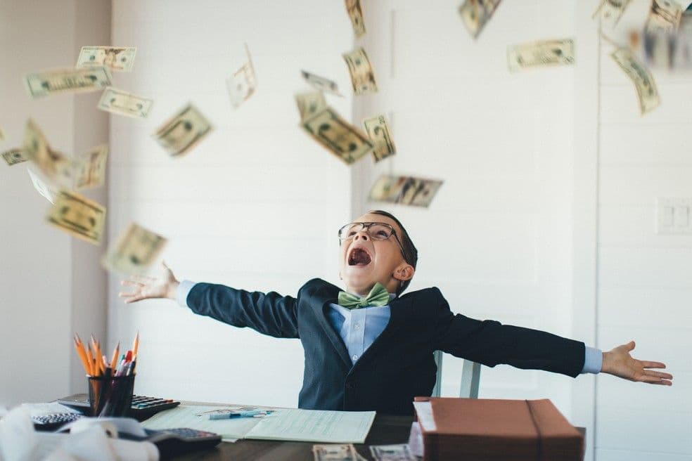 Enfant joyeux lançant de l'argent en l'air, représentant les retours positifs et la croissance du patrimoine grâce à un portefeuille diversifié avec CPFL.