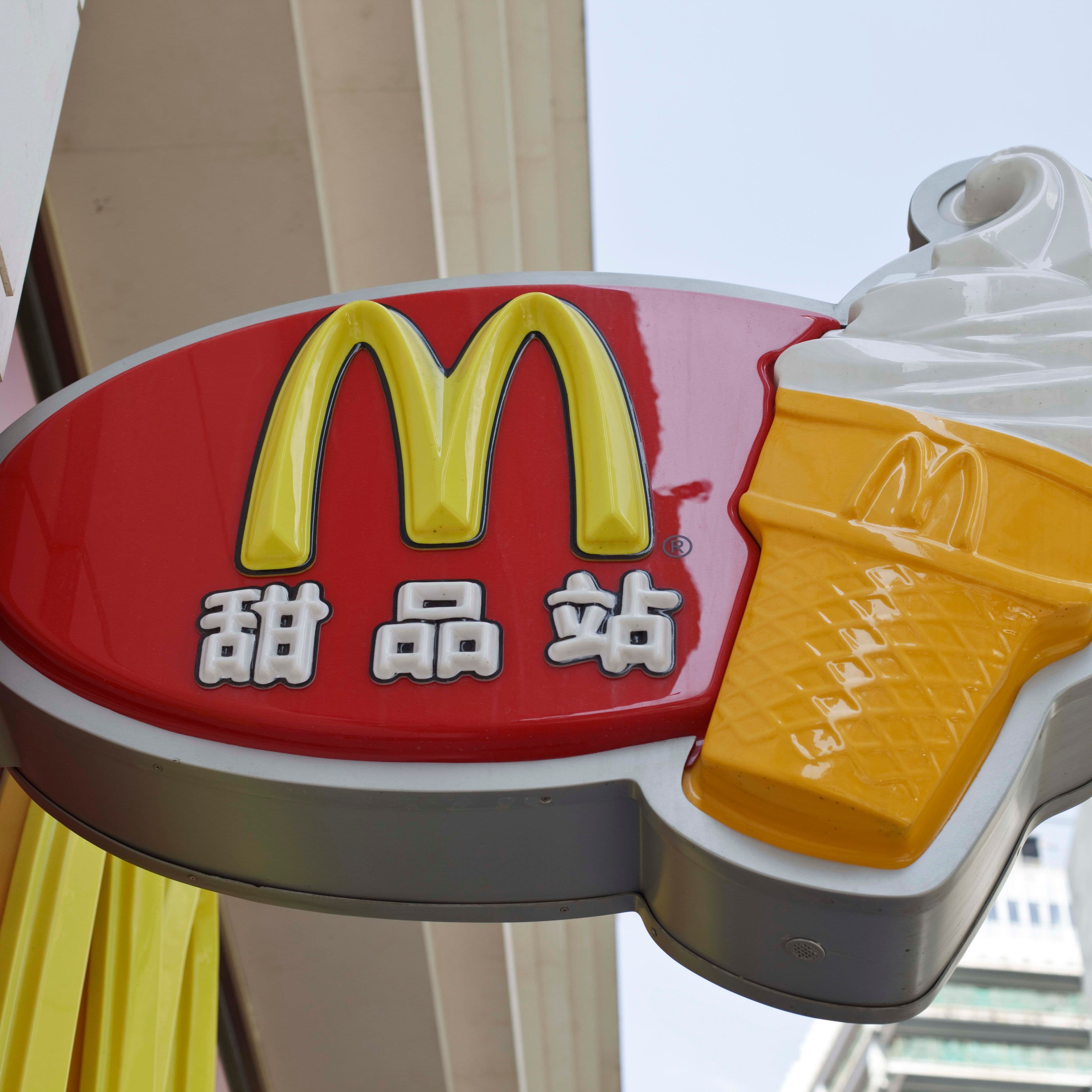 Enseigne McDonald's avec des caractères chinois et une icône de crème glacée, illustrant la présence globale et l'adaptation de la marque.