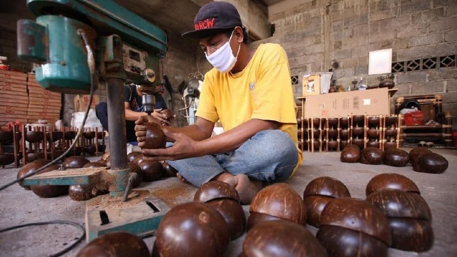 Entrepreneur indonésien travaillant dans un atelier, symbolisant le soutien du KUR BRI aux PME.