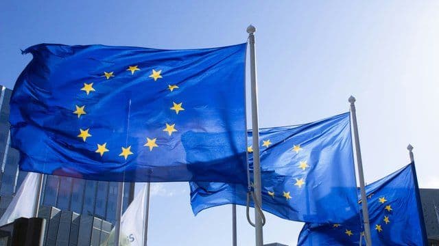 European Union flags waving in the wind, symbolizing ongoing integration and accession talks.