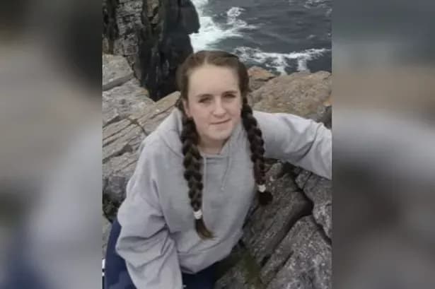 Féile O'Sullivan, une jeune fille aux tresses, assise sur des rochers au bord de la mer, symbolisant sa force et sa résilience.