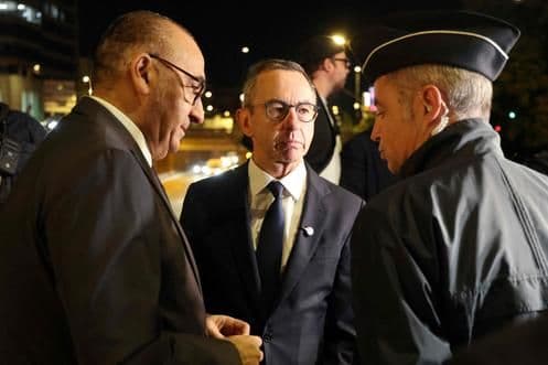 France's Minister of Interior and Paris police prefect consult with an officer, highlighting the close ties between state power and law enforcement during protests.