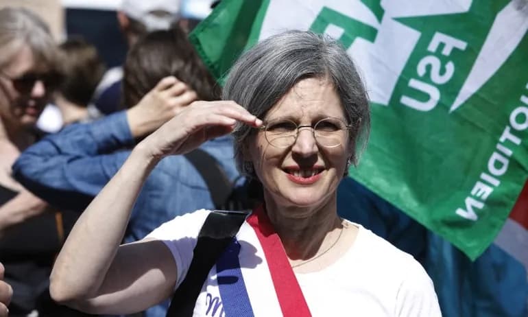 French politician Sandrine Rousseau wearing a tricolor sash, symbolizing French governance and environmental policy debate.