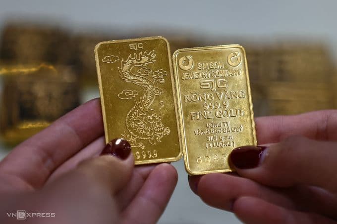 Hands holding SJC gold bars, symbolizing Vietnam's precious metals market and new digital transfer regulations.