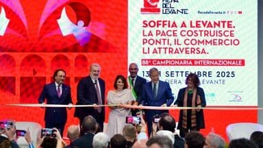 Inauguration ceremony of the 88th Fiera del Levante in Bari, Italy, featuring officials cutting a ribbon in front of a screen displaying the fair's theme: 'Soffia a Levante: Peace Builds Bridges, Commerce Crosses Them'.