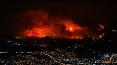 Incendie de forêt à Bursa la nuit, avec des flammes éclairant le ciel au-dessus de la ville.