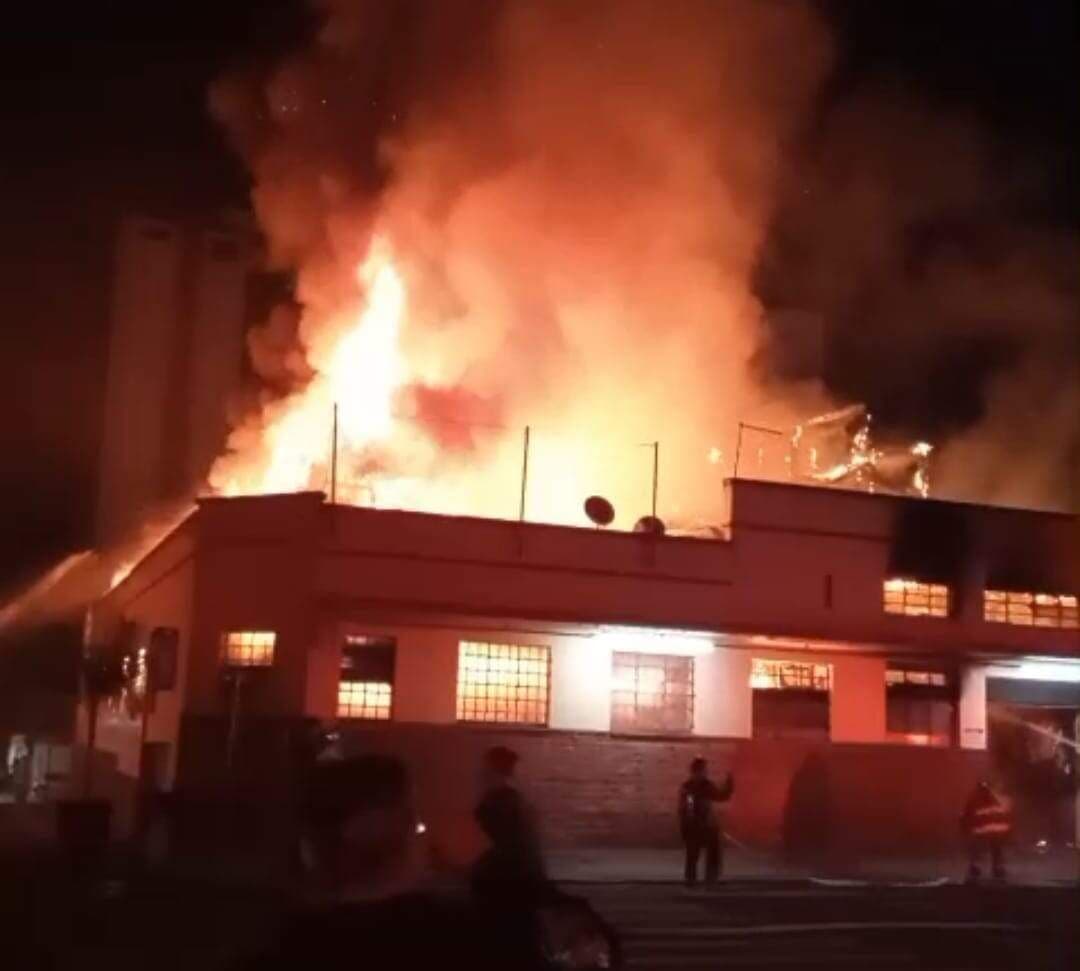 Incêndio massivo atinge o telhado do Mercado Municipal de Piracicaba à noite, com grandes chamas e fumaça.