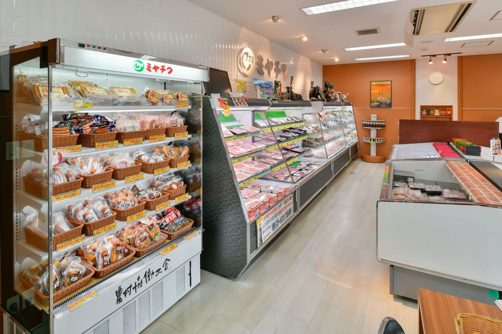Intérieur d'un point de vente direct Miyachiku, présentant des étals réfrigérés remplis de bœuf de Miyazaki et de porc de marque, soulignant la qualité des produits.