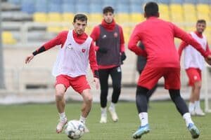 Iranian football players training on a field, symbolizing Mehdi Taremi's player profile and professional career.