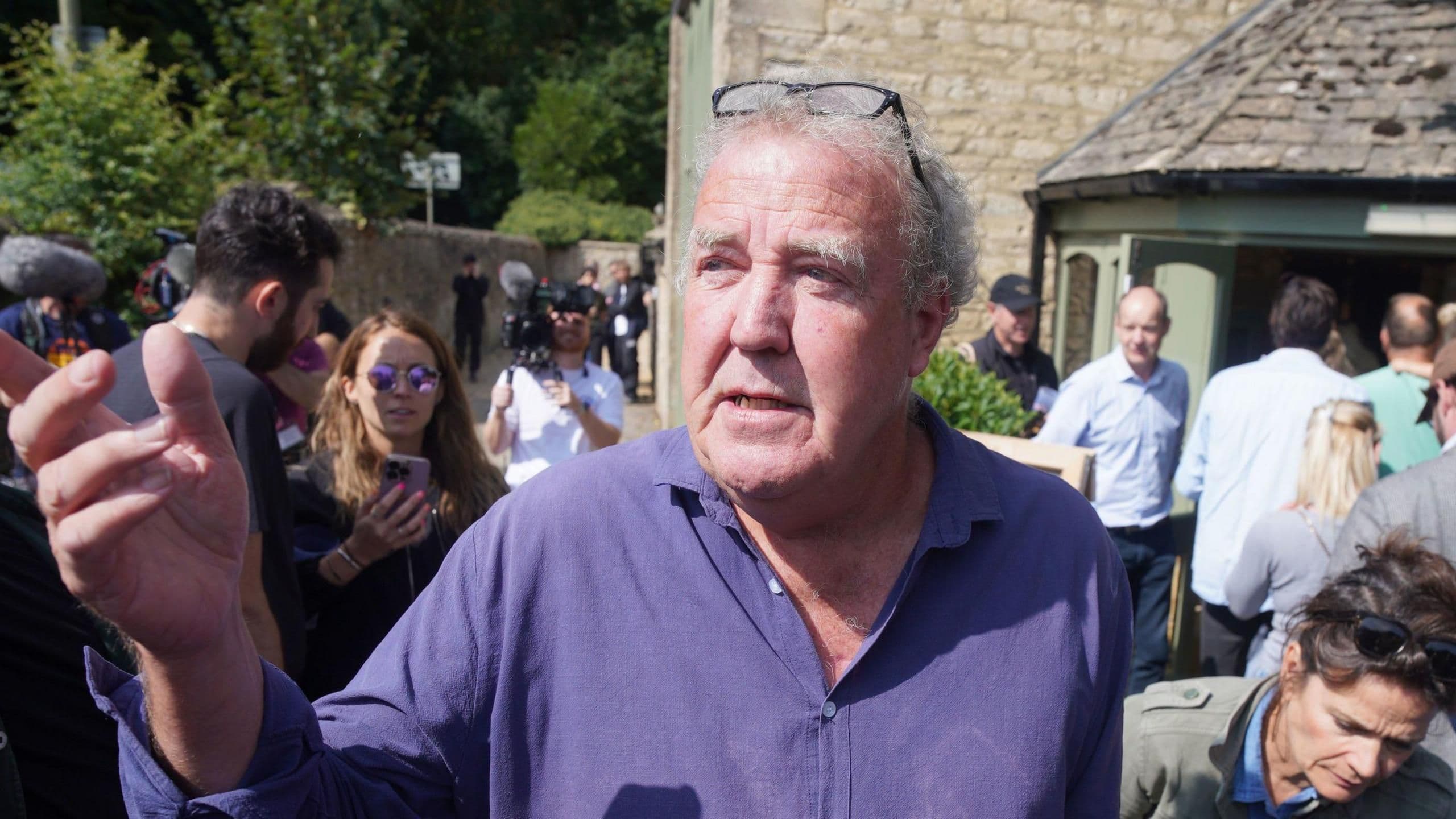 Jeremy Clarkson engaging with a crowd outside his Diddly Squat Farm pub, reflecting his journey from TV to farming reality.
