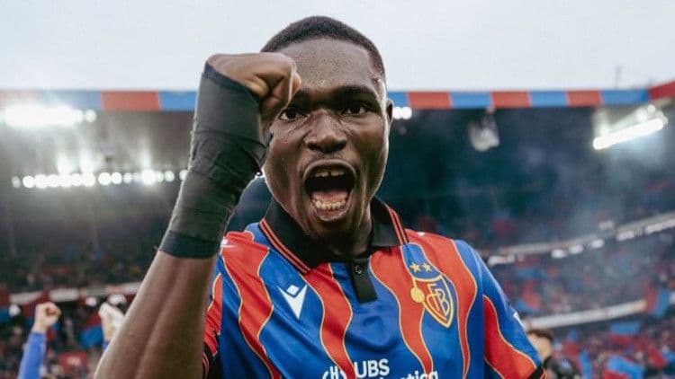 Jonas Adjetey celebrating a goal or victory in his FC Basel kit, symbolizing his meteoric rise and transfer buzz.
