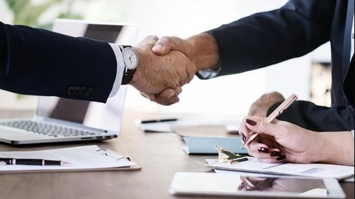 İki elin minyatür evler üzerinde tokalaşması, kiracılar ve ev sahipleri arasındaki yeni kira düzenlemeleri ve anlaşmaları temsil ediyor.