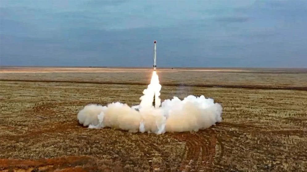 Lancement d'un missile balistique depuis un champ désertique, symbolisant la dissuasion nucléaire et la puissance militaire mondiale.