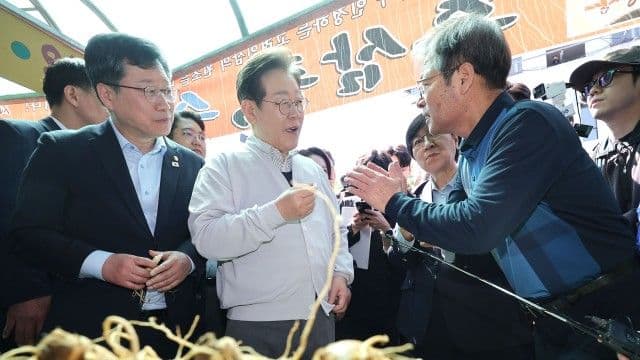 L'ancien gouverneur Lee Jae-myung interagissant avec des citoyens, représentant les dynamiques politiques.