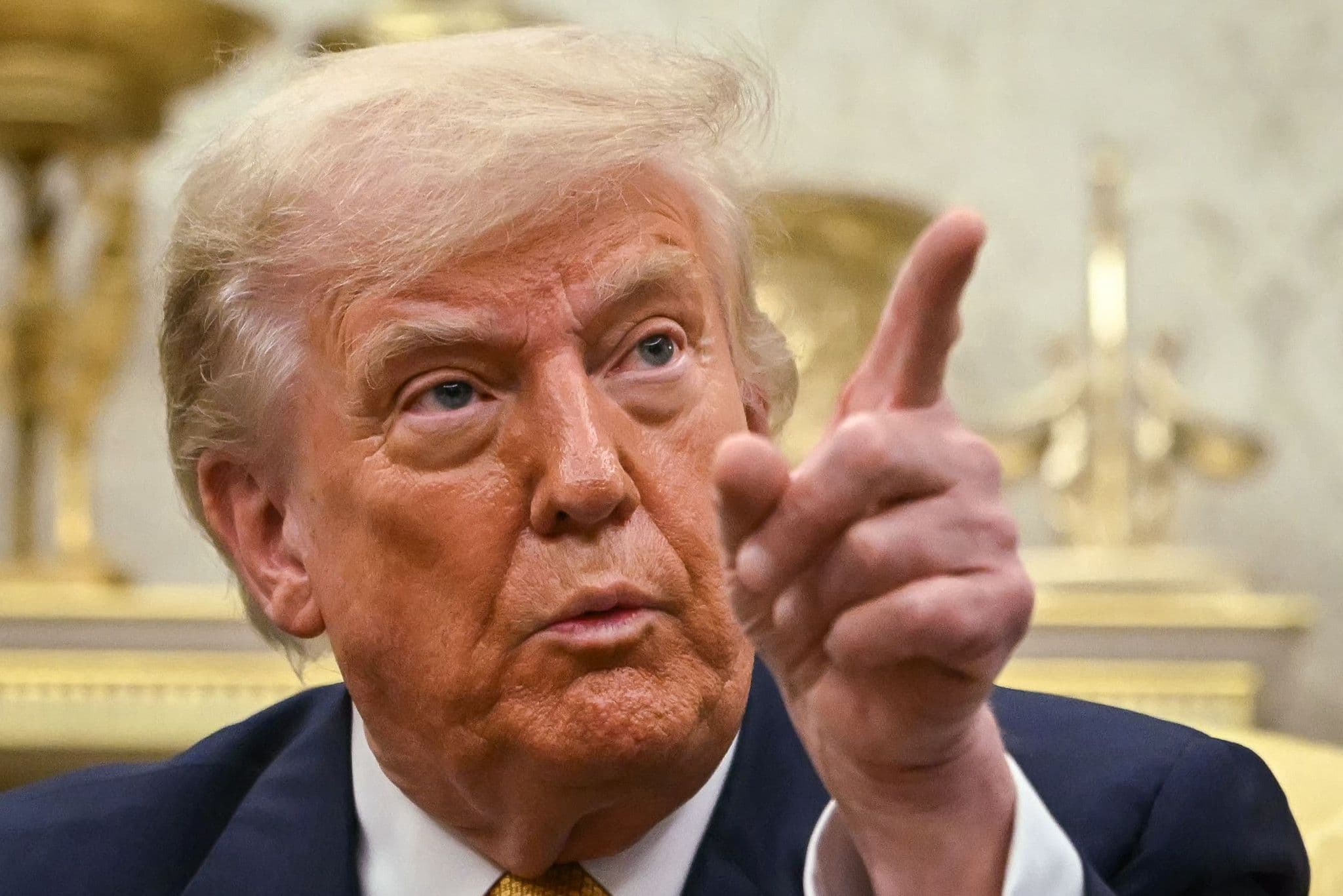 Le président américain Donald Trump pointant du doigt, représentant son approche transactionnelle et unilatérale.