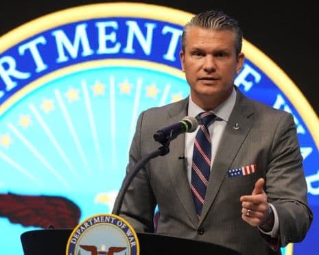 Le secrétaire à la Défense Pete Hegseth parle devant le logo du 'Département de la Guerre', symbolisant le virage militaire de l'Opération Southern Spear.