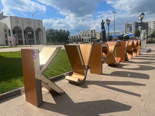 Les lettres géantes 'Koursk' sur une place de la ville sous un ciel nuageux, symbolisant la ville face aux changements climatiques.