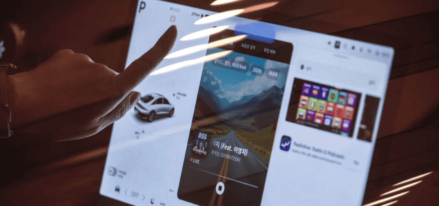Main interagissant avec un grand écran tactile affichant des applications, représentant l'intégration numérique et l'expérience immersive à KINTEX.