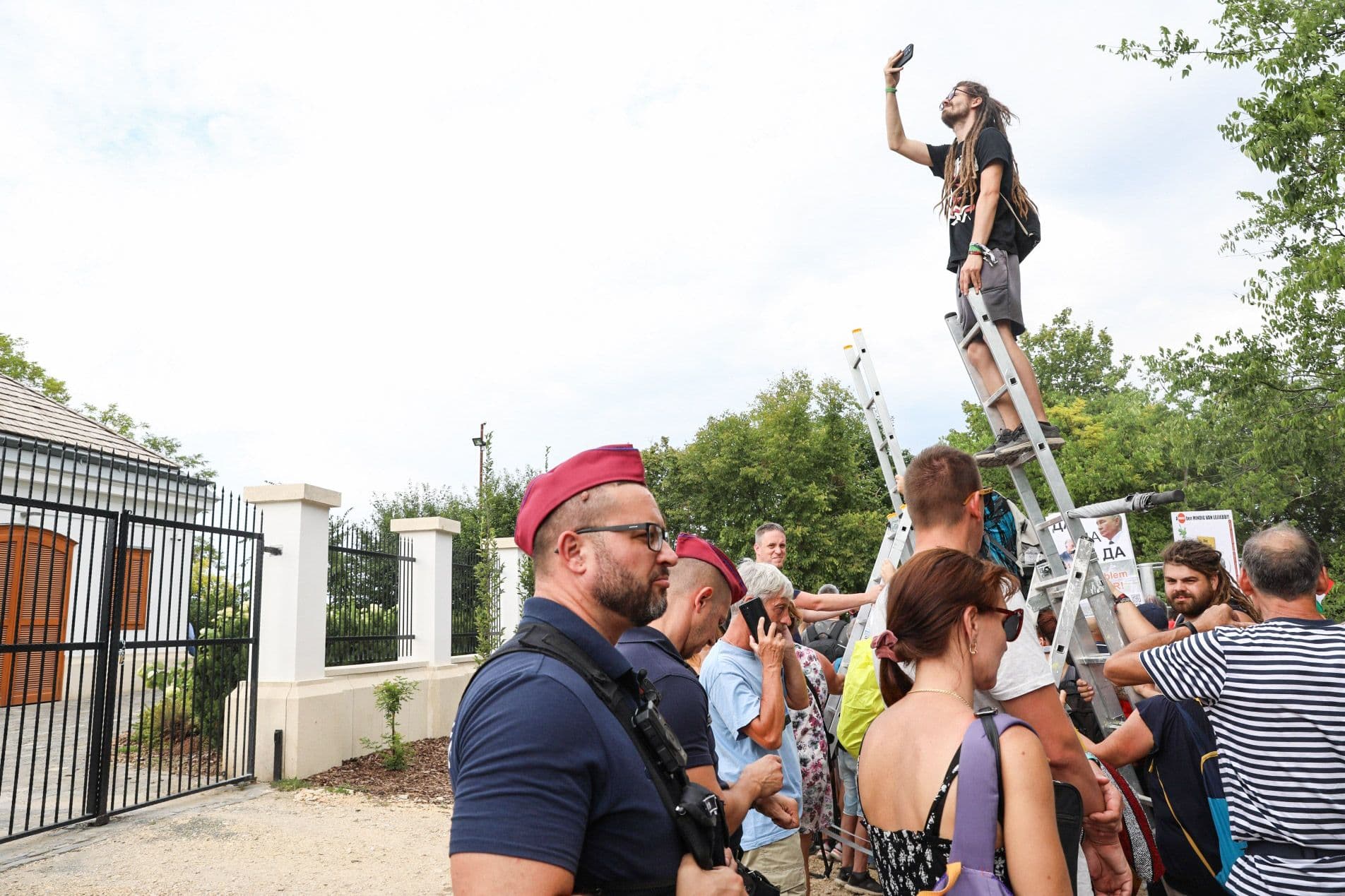 Manifestants sur des échelles observant le domaine de Hatvanpuszta sous la surveillance policière.