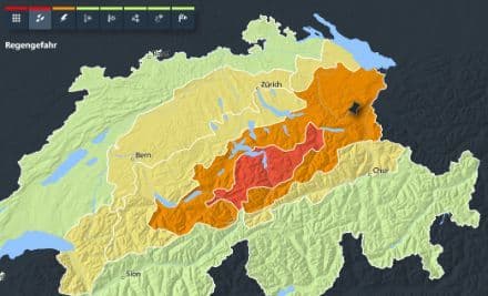 Map of Switzerland showing severe weather warnings for heavy rain across different regions, indicating high danger levels.