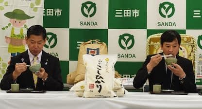 Mayors Ryota Nakagawa and Katsuya Tamura tasting Sanda-grown Koshihikari rice during their reconciliation visit.