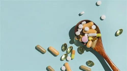 Médicaments et pilules sur une cuillère, symbolisant la gestion des symptômes du Chikungunya.