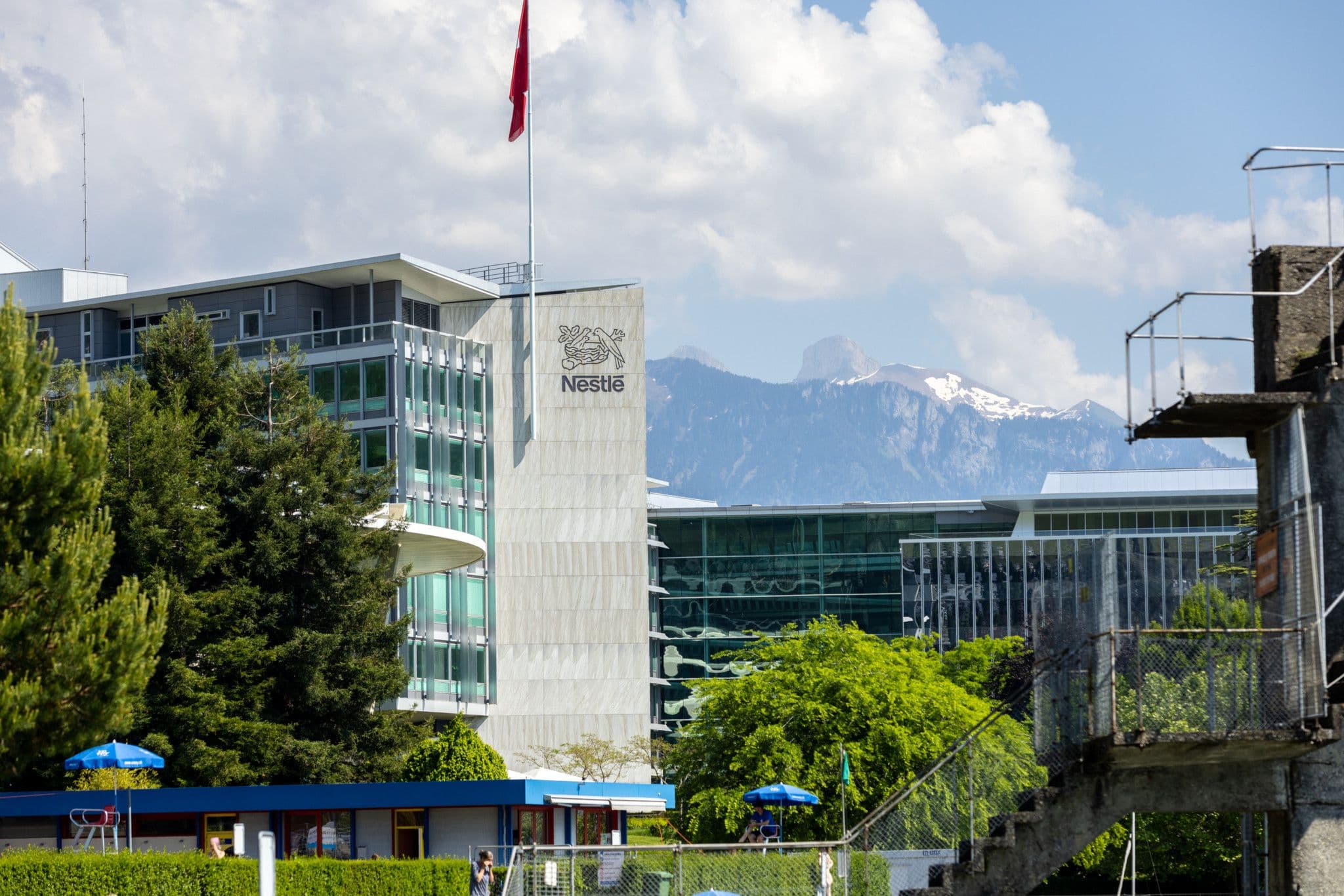Nestlé-Gebäude in der Schweiz mit Bergkulisse, symbolisiert die globale Präsenz und Stabilität des Unternehmens.