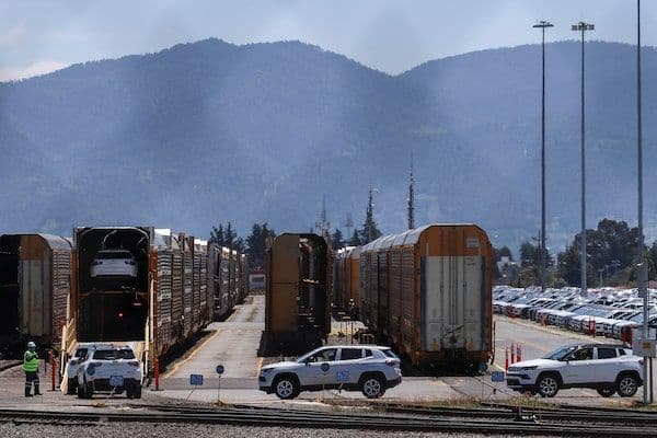 New automobiles being loaded onto train cars, illustrating North American trade and the impact of USMCA on supply chains.