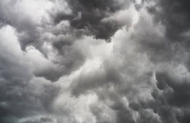 Nuvens escuras e carregadas, simbolizando frentes frias e corredores de umidade que afetam o clima do Brasil, influenciados pela La Niña.