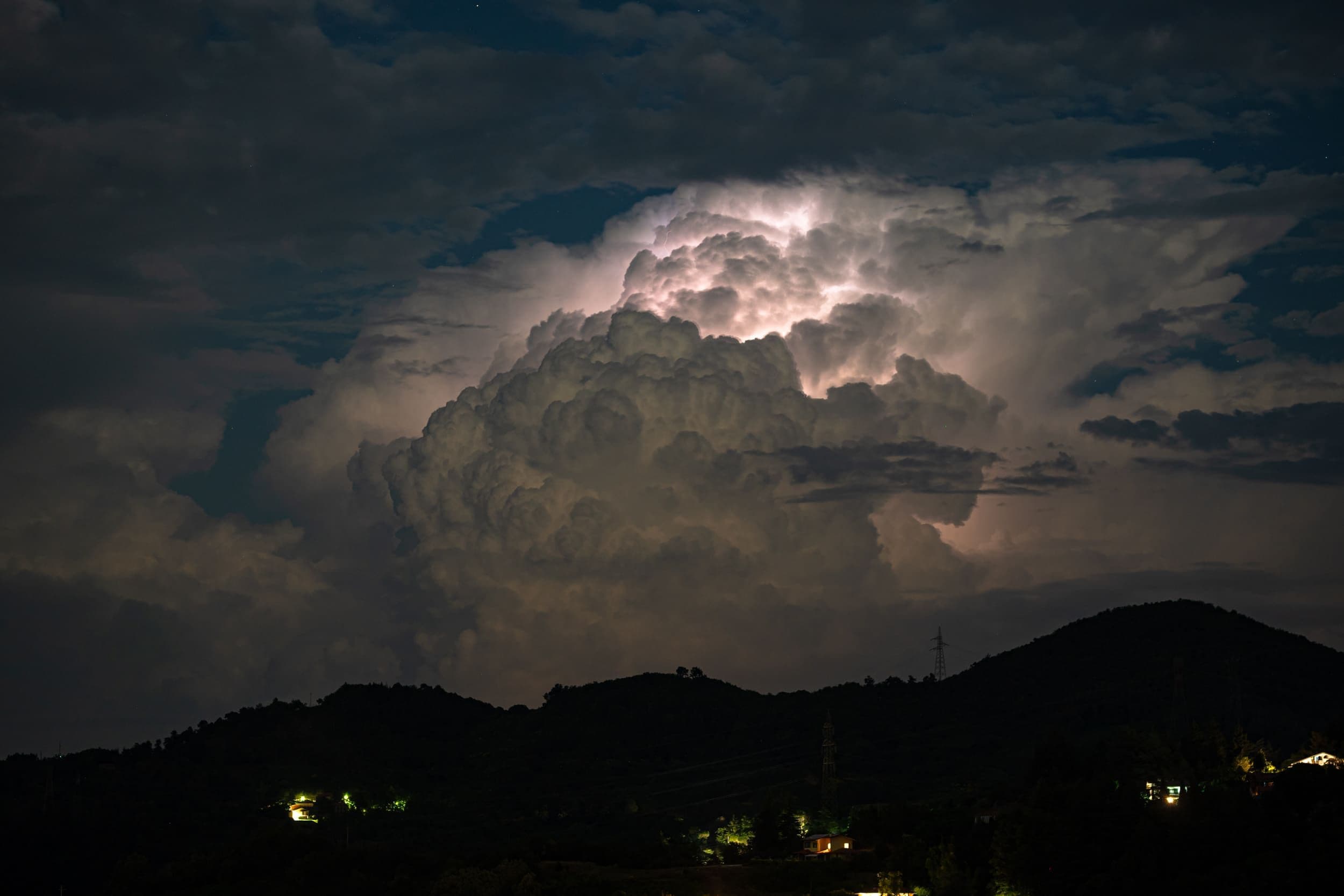 Orage intense et éclairs illuminant les montagnes alpines la nuit, symbolisant les intempéries extrêmes au Tyrol.
