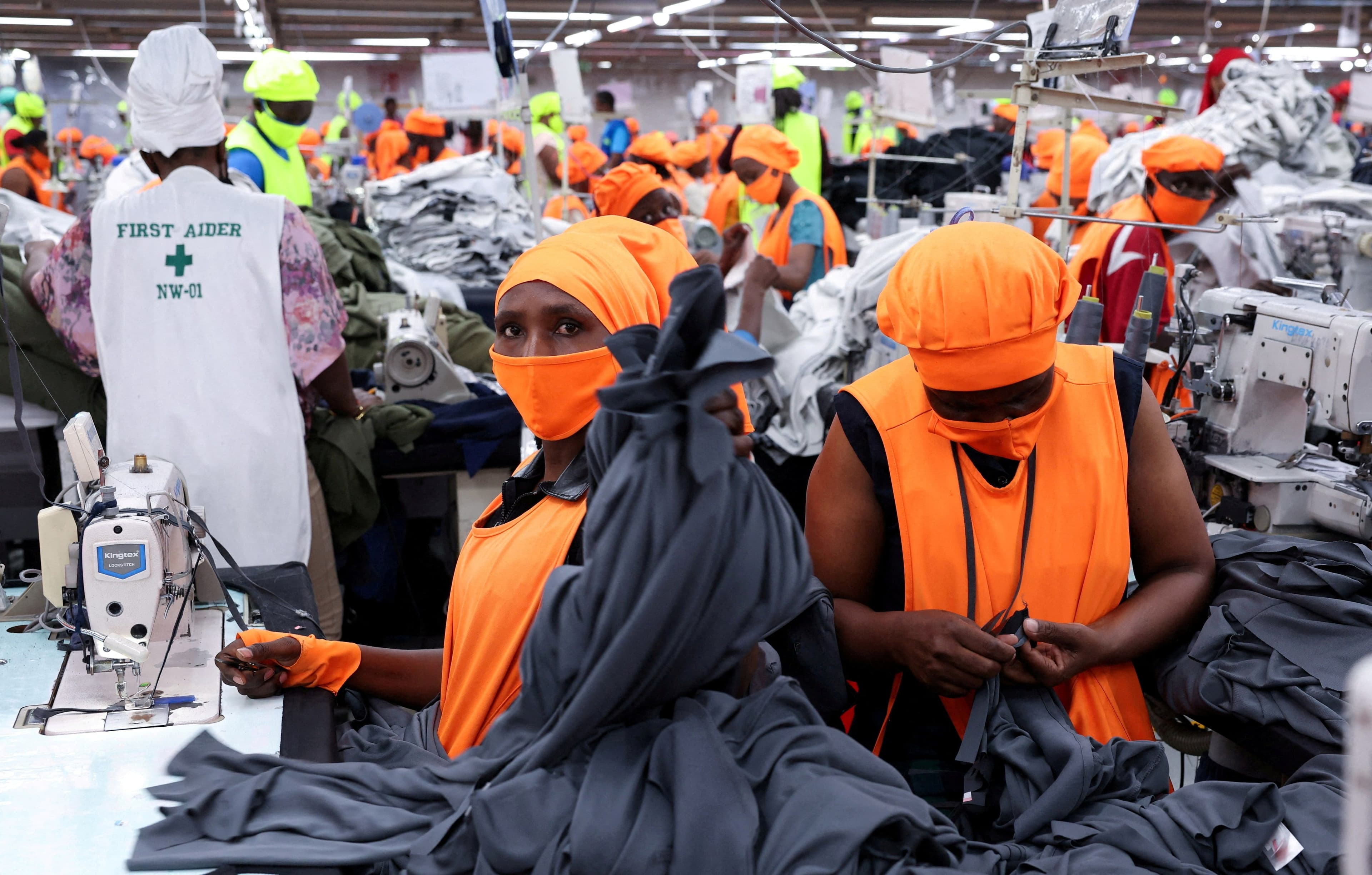 Ouvriers kenyans dans une usine de confection préparant des vêtements pour l'exportation, illustrant les enjeux d'AGOA pour l'emploi et le commerce africain.