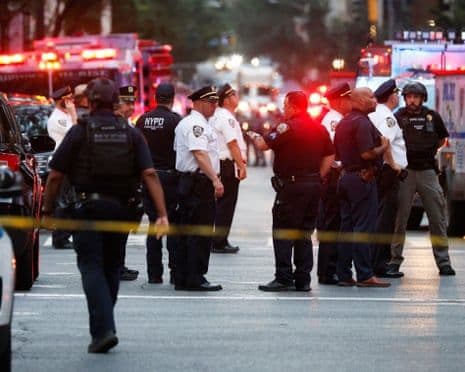 Policiers et véhicules d'urgence à New York après un incident de sécurité dans un gratte-ciel financier.