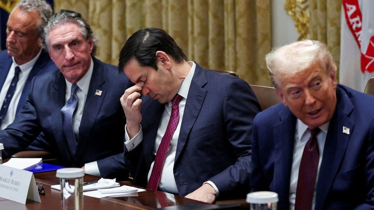 President Donald Trump and his cabinet members in a meeting, discussing trade policy and emergency powers