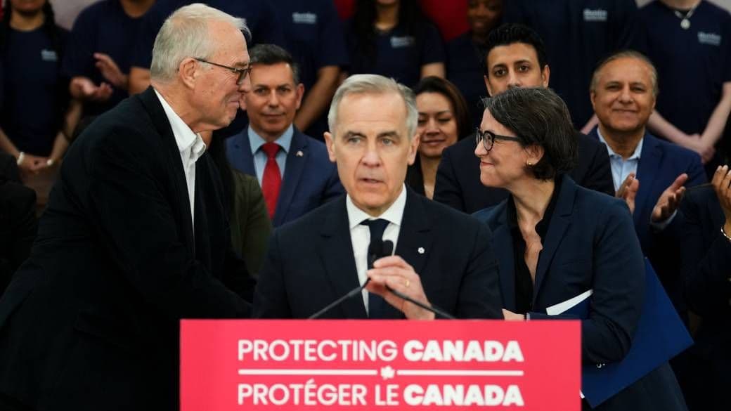 Prime Minister Mark Carney speaking at a podium with a 'Protecting Canada' sign, related to the gun buyback program.