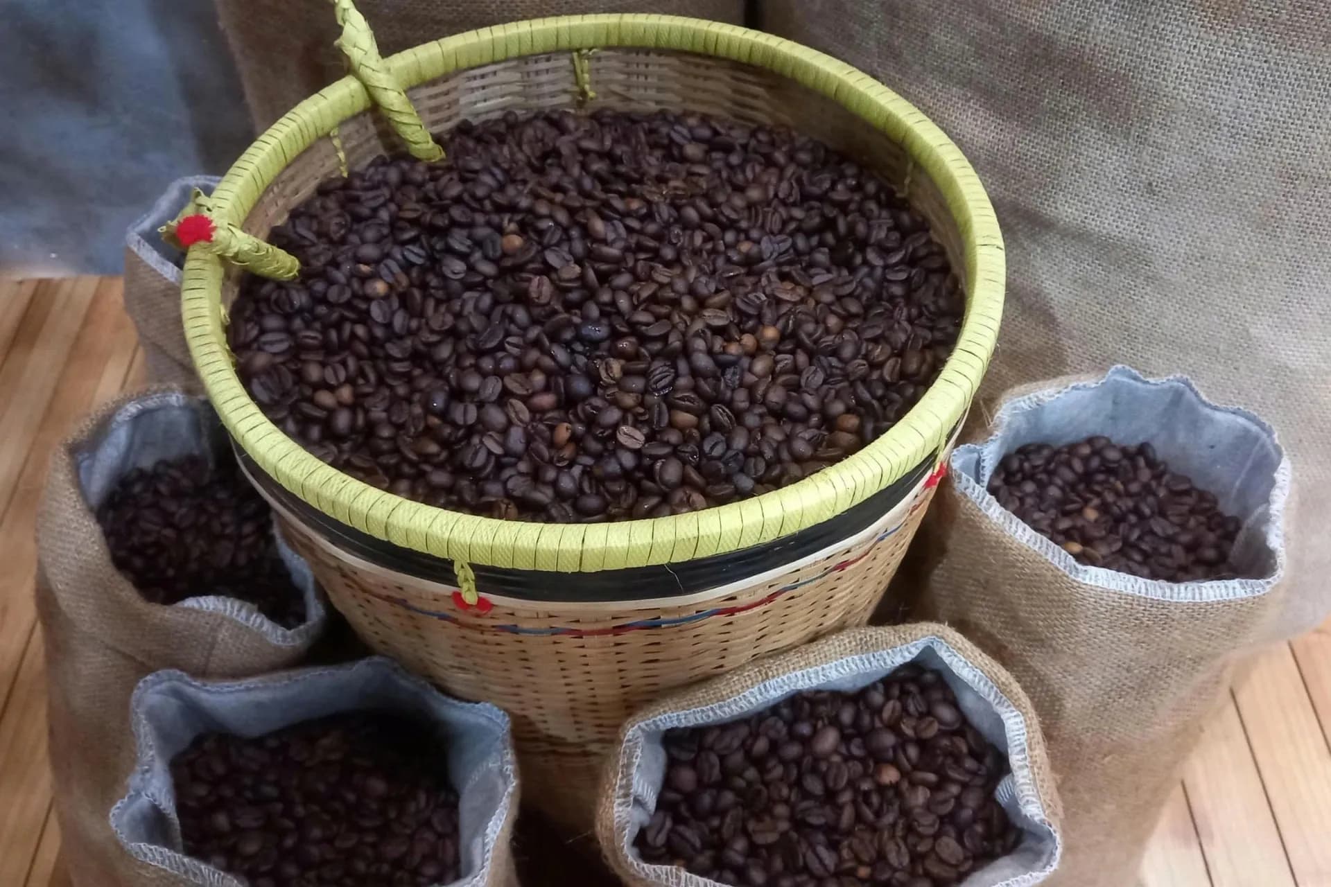 Processed coffee beans ready for export packed in traditional baskets and burlap sacks.