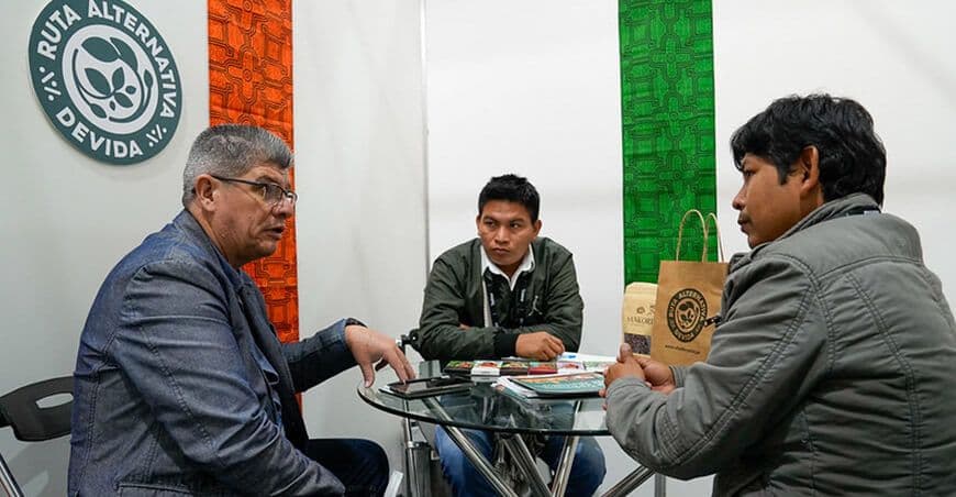 Productores de café y cacao de Devida en una reunión de negocios en Expoalimentaria, fortaleciendo cadenas de valor sostenibles.