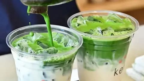 Préparation de deux lattes au matcha vert vif, symbolisant la popularité mondiale du matcha.