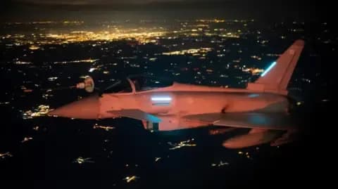 RAF Eurofighter Typhoon jet flying at night over a city, on an Eastern Sentry mission over Poland, symbolizing air defense and deterrence.