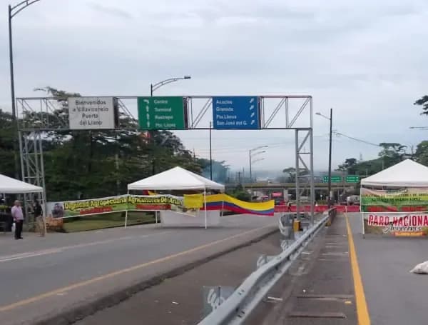 Route bloquée par des manifestants avec des banderoles en Colombie.