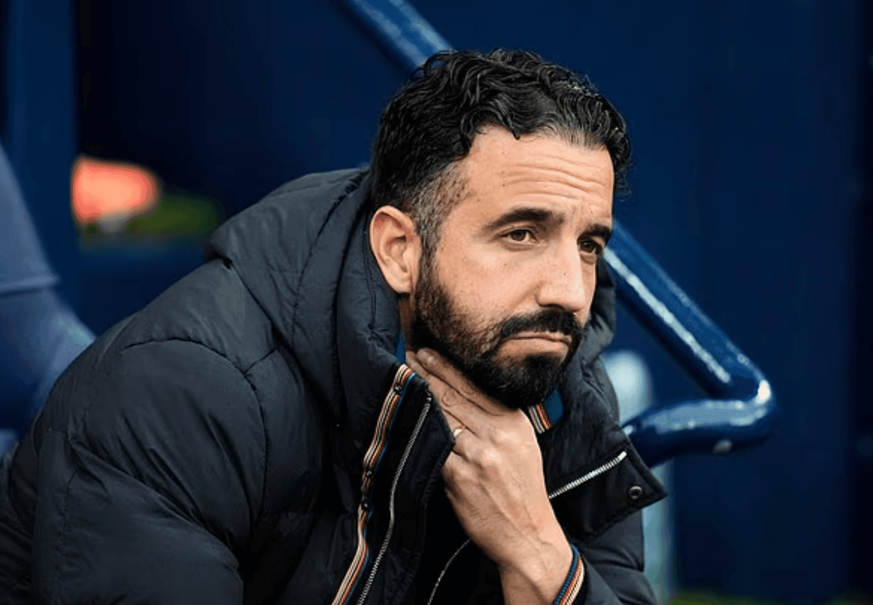 Ruben Amorim, Manchester United manager, looking pensive on the bench, reflecting his unwavering tactical philosophy.