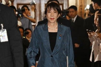 Sanae Takaichi, figure politique japonaise, marchant dans un couloir du parlement, au cœur des spéculations sur son futur cabinet.