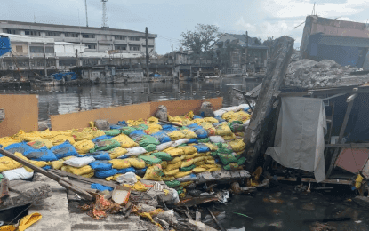 Sandbag barriers and construction along a waterway, representing infrastructure improvements for flood control and climate resilience.