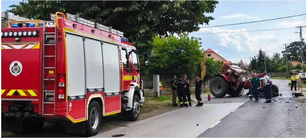 Scene of a fatal road collision in Piricsen, Hungary, showing a fire truck, damaged agricultural tractor, and emergency personnel on a rural road.