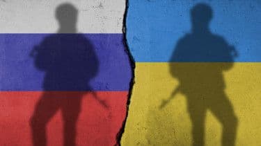 Shadows of soldiers on a cracked wall with Russian and Ukrainian flag colors, representing the Ukraine conflict and geopolitical tensions.